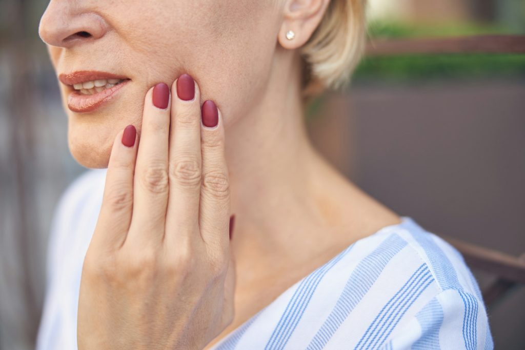 Female suffering from an acute dental pain